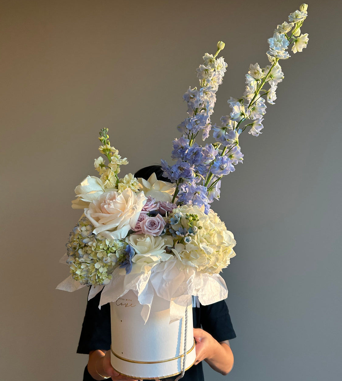 Bouquet of flowers in a white box against a light gray background